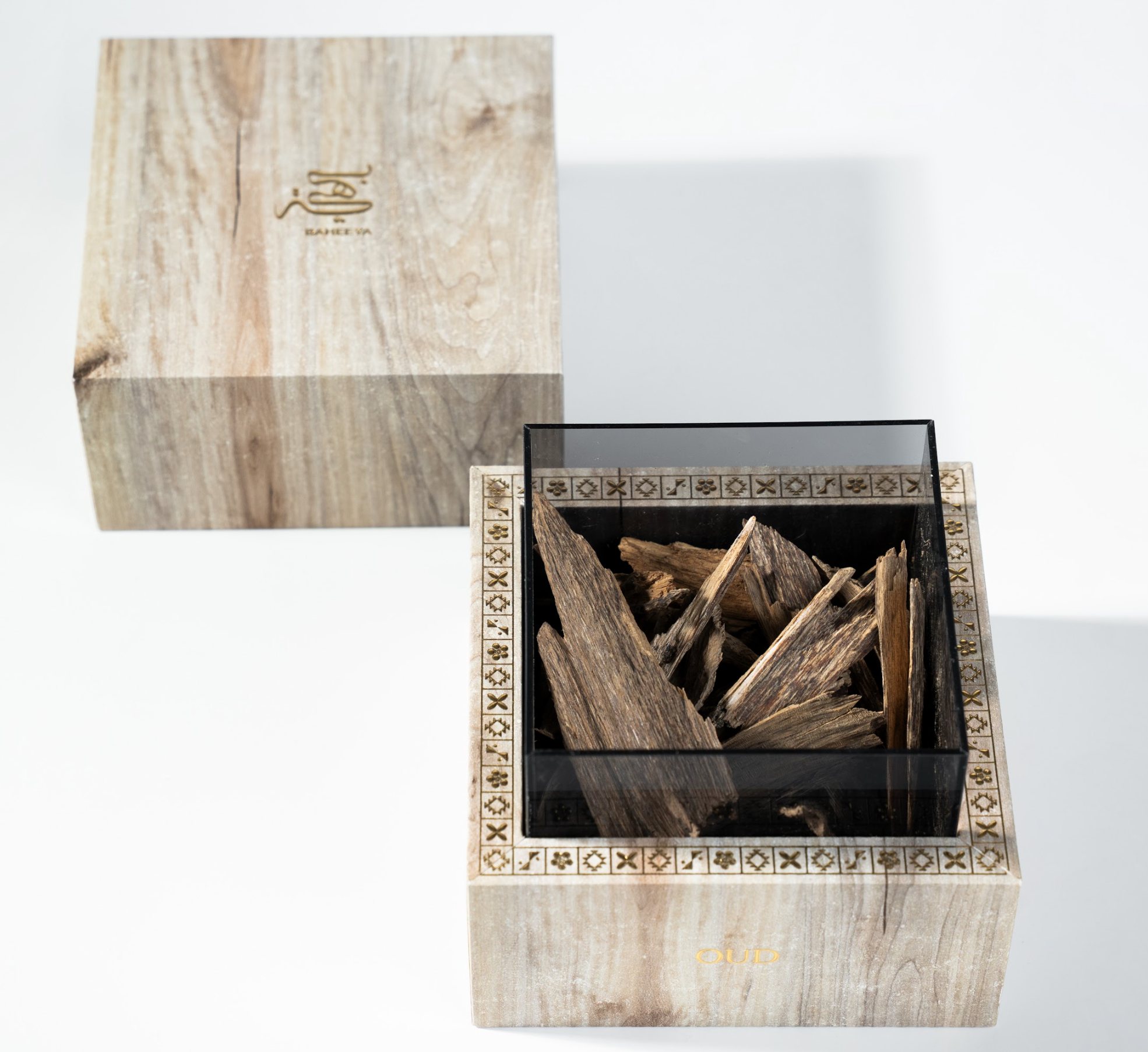 Wooden box with decorative patterns containing wooden sticks, on a white background