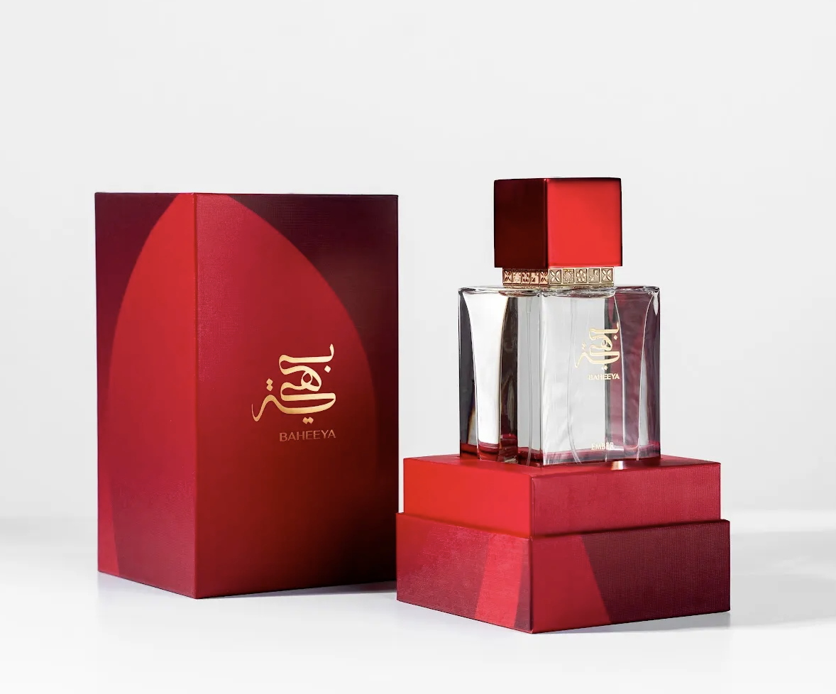 Perfume bottle and packaging with a red and gold design on a white background